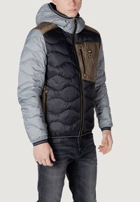 Polstret jakke med et farveblokdesign i grå, marineblå og brun, lynlåslomme foran og stribede manchetter med hætte.