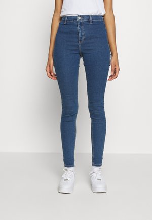Jeans ajustados de mezclilla en azul, con un diseño de cintura alta, estilo de cinco bolsillos y un sutil detalle de costura en contraste.