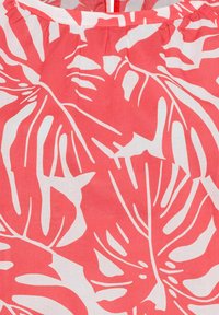 Roter und weißer Stoff mit einem auffälligen Print von Monstera-Blättern. Leichter Textur mit einer glatten Oberfläche und gerafften Kragendetails.