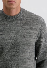 Grijs gebreid sweater met een gestructureerd patroon en geribbelde halslijn. De stof lijkt zacht en warm, met verschillende tinten grijs doorheen.