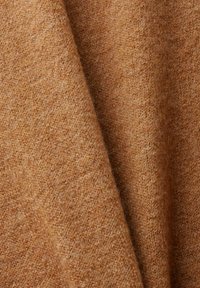 Tissu tricoté brun avec une texture douce, présentant un motif chiné subtil et de légères variations de teinte.