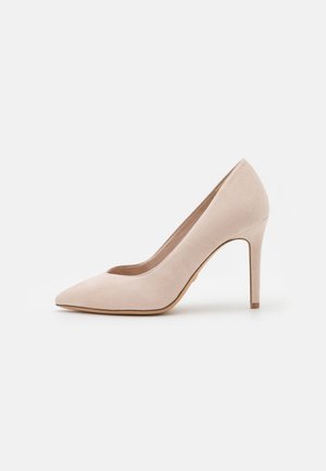 Beżowe zamszowe szpilki z wąskim noskiem i smukłym obcasem w stylu stiletto. Gładka faktura i minimalistyczny design bez ozdób.