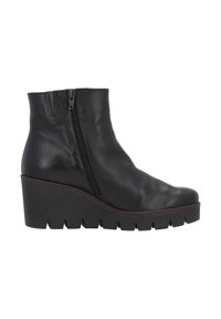 Bottine en cuir noir avec un talon compensé, fermeture éclair latérale, texture lisse et semelle épaisse présentant des rainures horizontales.