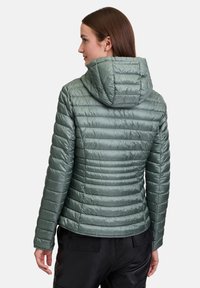 Gewatteerde groene jas met een capuchon, kenmerkend door diagonale stiksels en een glanzende, gladde textuur. Het ontwerp is aansluitend met een iets verkorte zoom.