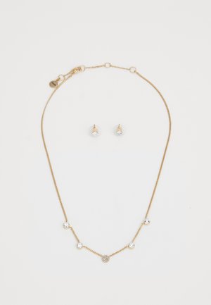Collana in tono dorato con accenti di cristallo rotondi e un design circolare centrale; abbinata a orecchini a perno coordinati con pietre trasparenti.