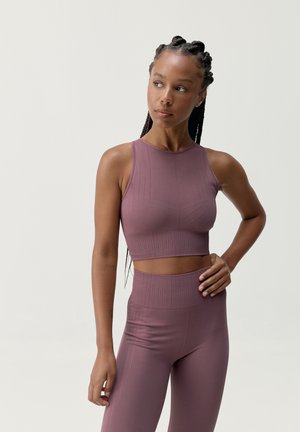 Top corto atlético en color mauve con un diseño texturizado y un dobladillo acanalado, combinado con leggings de cintura alta que cuentan con detalles de patrón similares.
