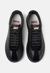 Black sneakers with a mixed leather and suede upper, round toes, flat laces, and a "CAMPER" logo on the tongue and insole.