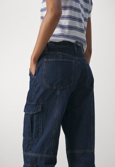 Pantaloni cargo din denim închise, cu o croială lejeră, având mai multe buzunare, detalii cusute și o textură netedă.
