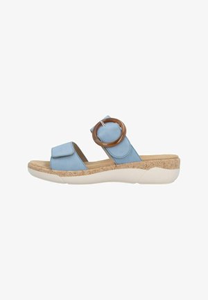 Light blue open-toe slide sandal with wide straps, large brown circular buckle, textured midsole, and cushioned white platform sole.