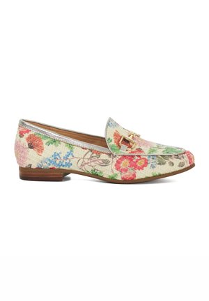 Mocassins floraux avec un tissu crème texturé, présentant un motif coloré de fleurs roses, rouges et bleues, et un détail de boucle en ton doré.