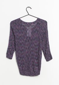 Pull en tricot violet à manches trois-quarts, présentant un motif texturé et un col rond, suspendu sur un cintre noir contre un fond blanc.
