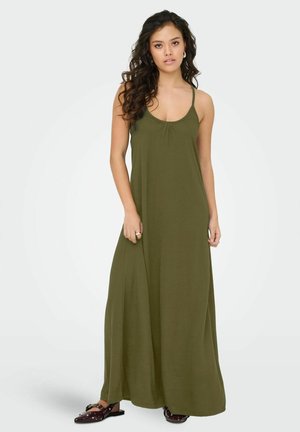 Robe maxi sans manches en vert olive avec un col rond et des détails froncés. Tissu fluide avec une texture lisse. Associée à des chaussures sombres à enfiler.
