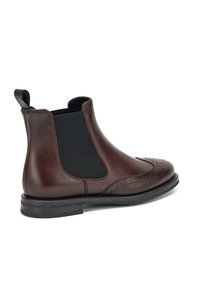 Stivale Chelsea in pelle marrone con finitura liscia, pannelli laterali elasticizzati, dettagli perforati sulla punta e suola in gomma nera.