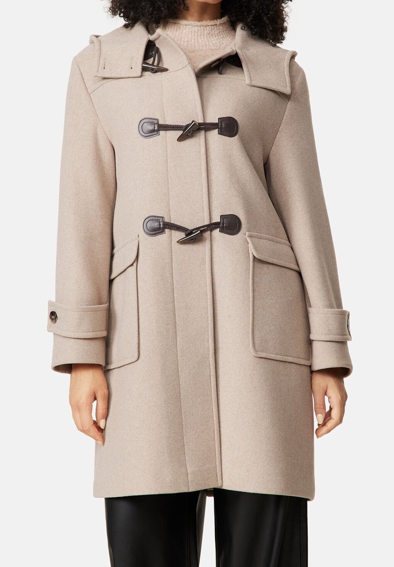 Manteau duffle beige en mélange de laine, présentant des fermetures à brandebourg, deux poches avant et un col repliable. Texture douce et coupe décontractée.