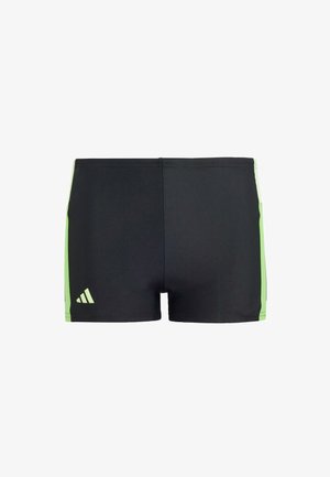 Pantaloni da nuoto neri con inserti verdi, realizzati in materiale elastico. Presentano un design minimalista con il logo Adidas sul lato sinistro inferiore.