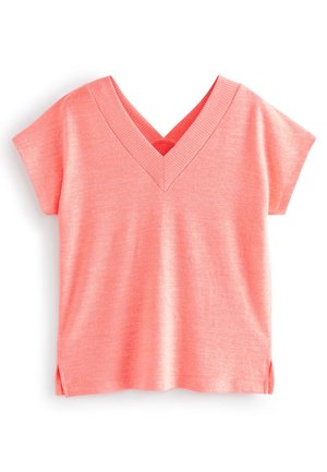 Haut à manches courtes et col en V de couleur corail, fabriqué dans un tissu doux et lisse. Caractérisé par un col côtelé et des fentes latérales pour une meilleure liberté de mouvement.