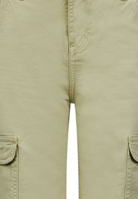 Khaki cargobroek met meerdere zijzakken, zichtbare stiksels en een zachte katoenmix stof. Voorzien van een rits aan de voorkant en een knoopsluiting.