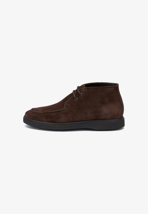 Stivali alla caviglia da uomo in suede marrone scuro con suola in gomma nera, chiusura con lacci a due fori e cuciture dettagliate su sfondo bianco.