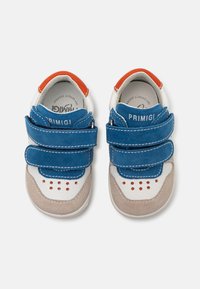 Chaussures d'enfants bleu et beige avec des bandes velcro, présentant une texture en cuir lisse et en suède, des accents rouges et des motifs perforés.
