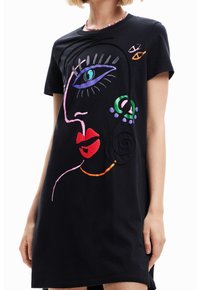Czarna bawełniana sukienka T-shirt z kolorowym wzorem twarzy w różnych odcieniach, z krótkimi rękawami i okrągłym dekoltem.