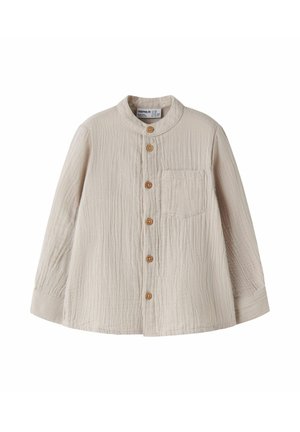 Beige langærmet skjorte til småbørn med rund krave, træknapper foran og brystlomme, lavet af struktureret stof.
