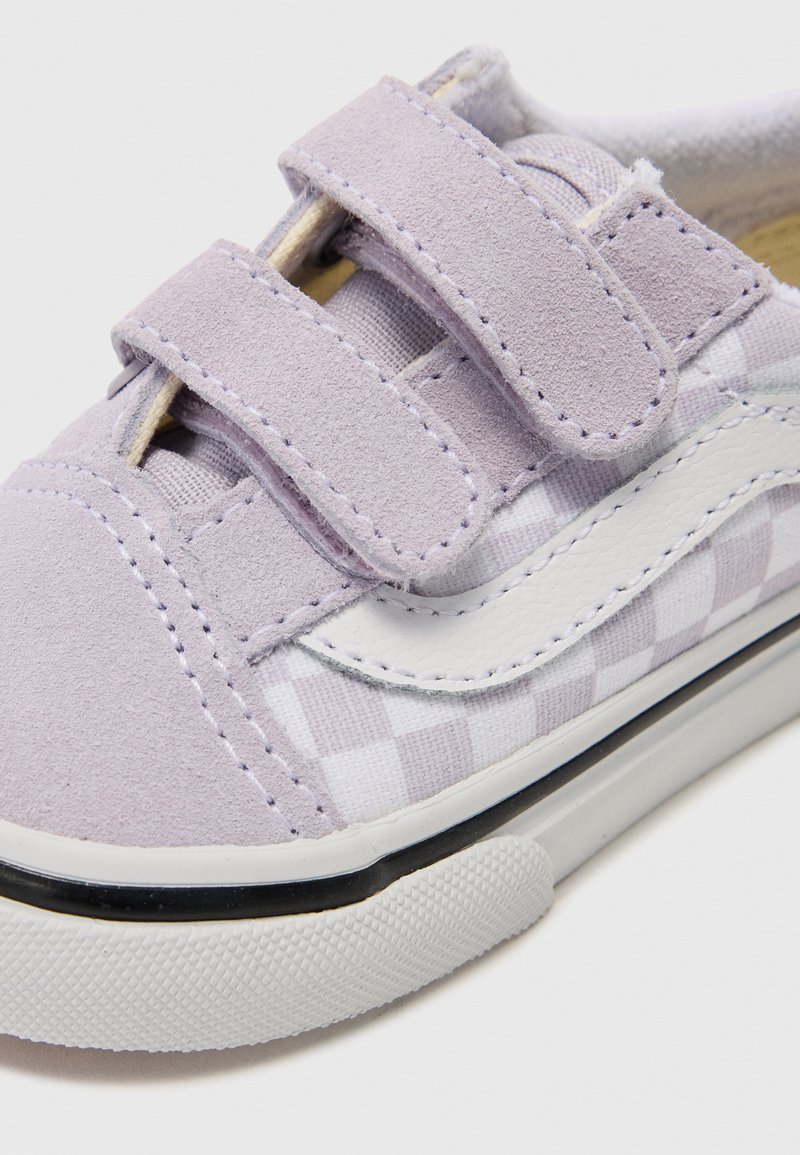 Helllila Velcro-Sneaker mit einem karierten Muster, weißen Lederakzenten und einer Gummisohle mit strukturiertem Grip und schwarzem Streifen.