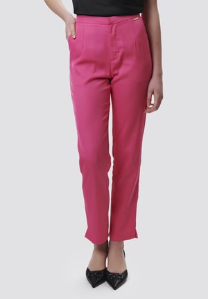 Pink tailored trousers with a smooth texture, mid-rise waist, side pockets, and a straight leg design, paired with black pointed heels.