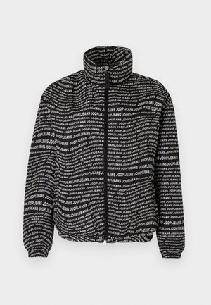 Black padded jacket featuring an all-over white text pattern. High collar, zip closure, elasticized cuffs, and hem for a snug fit.