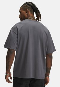 Grå bomulds T-shirt med korte ærmer, afslappet pasform og rund hals. Glat tekstur, minimalistisk design og ingen synlige mønstre eller logoer.