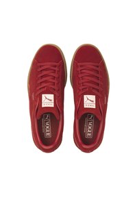 Zapatillas de ante rojas con una forma redondeada, con cordones planos, una etiqueta con el logotipo en la lengua y una suela de goma texturizada.