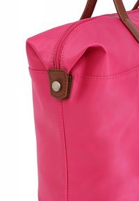Roze nylon tote bag met bruine leren accenten, voorzien van een ritssluiting en een ronde vorm; gladde textuur en verstevigde stikdetails.