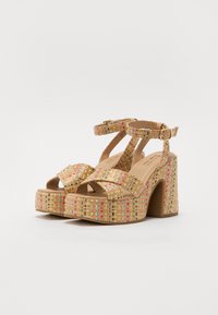 Woven platform sandals in beige, featuring multicolored accents, wide straps, and an ankle buckle. Chunky block heel design.