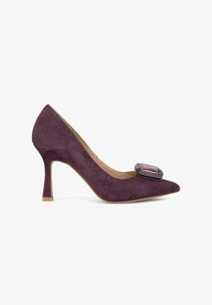 Escarpin en suede violet avec un bout pointu et un accent décoratif en pierre précieuse sur le dessus de la chaussure. Dispose d'un talon aiguille et d'un intérieur lisse.
