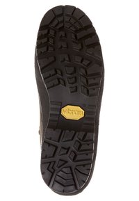 Μαύρη καουτσούκ σόλα με βαθιά πέλματα, που διαθέτει λογότυπο Vibram. Ο σχεδιασμός περιλαμβάνει γωνιακά μοτίβα και αυλακώσεις για πρόσφυση και ανθεκτικότητα.