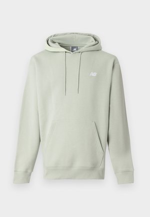 Sudadera con capucha de color gris claro, con bolsillo frontal, capucha ajustable con cordones y pequeño logo blanco de New Balance en el pecho izquierdo.