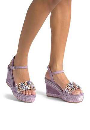 Lavender wedge sandals with a suede finish, featuring a jeweled footbed, open toe, and ankle strap. Braided rope midsole for texture.