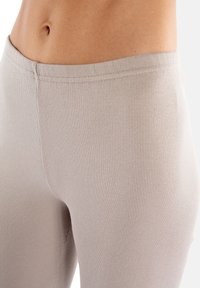 Jasno beżowe legginsy rybaczki z dopasowanym krojem, o gładkiej fakturze i elastycznym pasie dla wygody.