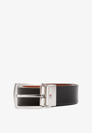 Ceinture en cuir noir avec une boucle rectangulaire en argent, présentant un petit détail de logo près de la boucle. Texture lisse et design classique.