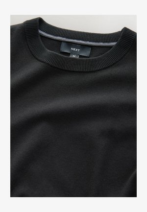 Črna jopica s krojnim ovratnikom iz gladkega blaga, z ribastim ovratnikom in manšetami, ter oznako blagovne znamke 'NEXT' in velikosti 'M'.