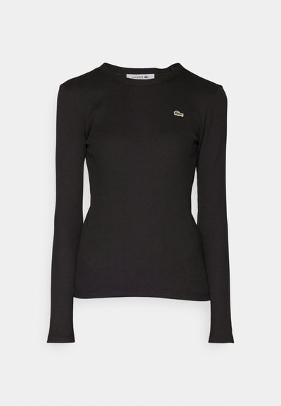 Chemise noire à manches longues en tissu côtelé avec un col rond et un logo vert brodé sur la poitrine gauche. Coupe ajustée.