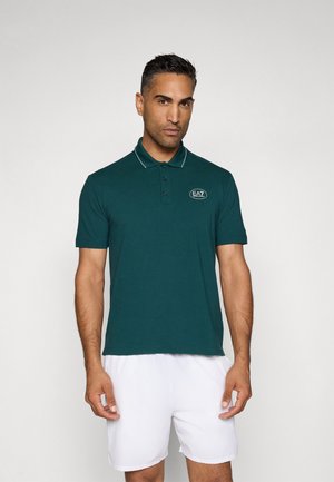 Donkergroene polo met witte accenten, korte mouwen en een knoopsluiting met drie knopen, met een geborduurd logo op de borst.