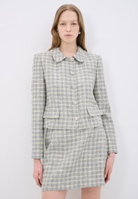Tweedblazer med rund krage, sex knappar fram och matchande kjol. Ljusblå och krämfärgad rutmönster, texturerad tyg.