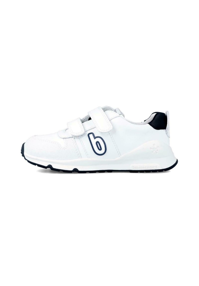 Zapatilla deportiva blanca con tiras de Velcro, parte superior de tela y sintético, acentos en navy, punta redonda, suela acolchada y detalle del logo en el lateral.