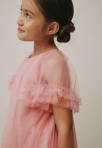 Rosa durchsichtige Kleid mit Rüschensleeves, leichtem Stoff und subtilen metallischen Akzenten. Glatte Textur mit einem fließenden Design.