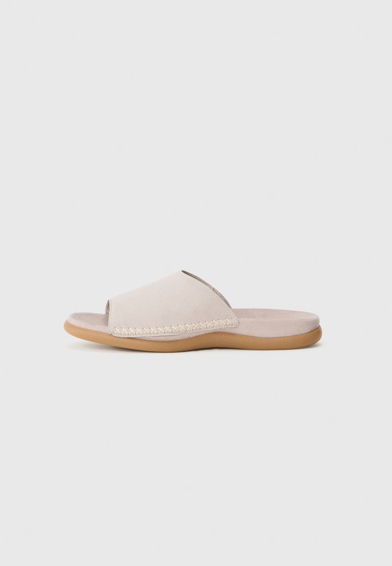 Sandale plate beige clair avec un bout ouvert et des détails tissés le long du bord, sur fond blanc uni.