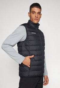 Zwarte puffy gilet met een hoge kraag, ritsluiting en schuine zakken. Lichtgewicht materiaal met horizontaal gestikte patroon en logo.
