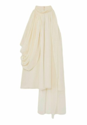 Epäröä muruvalkoinen hame, jossa on kootussa vyötäröllä kerroksellista, roikkuvaa kangasta yhdellä puolella, luoden pehmeän ja elegantin siluetin.