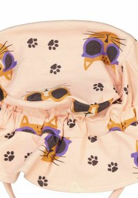 Ljusrosa bomullshatt med rynkad kant som pryds av ett katttryck med orange och lila solglasögon, omgiven av svarta tassavtryck.