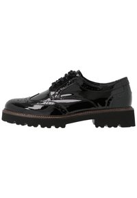 Sorte patenteret lædersko med brogue-design, tyk struktureret sål og klassiske vinge-tip detaljer. Har runde snørebånd og glat finish.