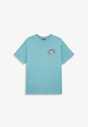 Jasnoniebieska koszulka z krótkim rękawem wykonana z bawełny. Na klatce piersiowej znajduje się grafika stylizowanego stwora ze skrzydłami i deską surfingową.